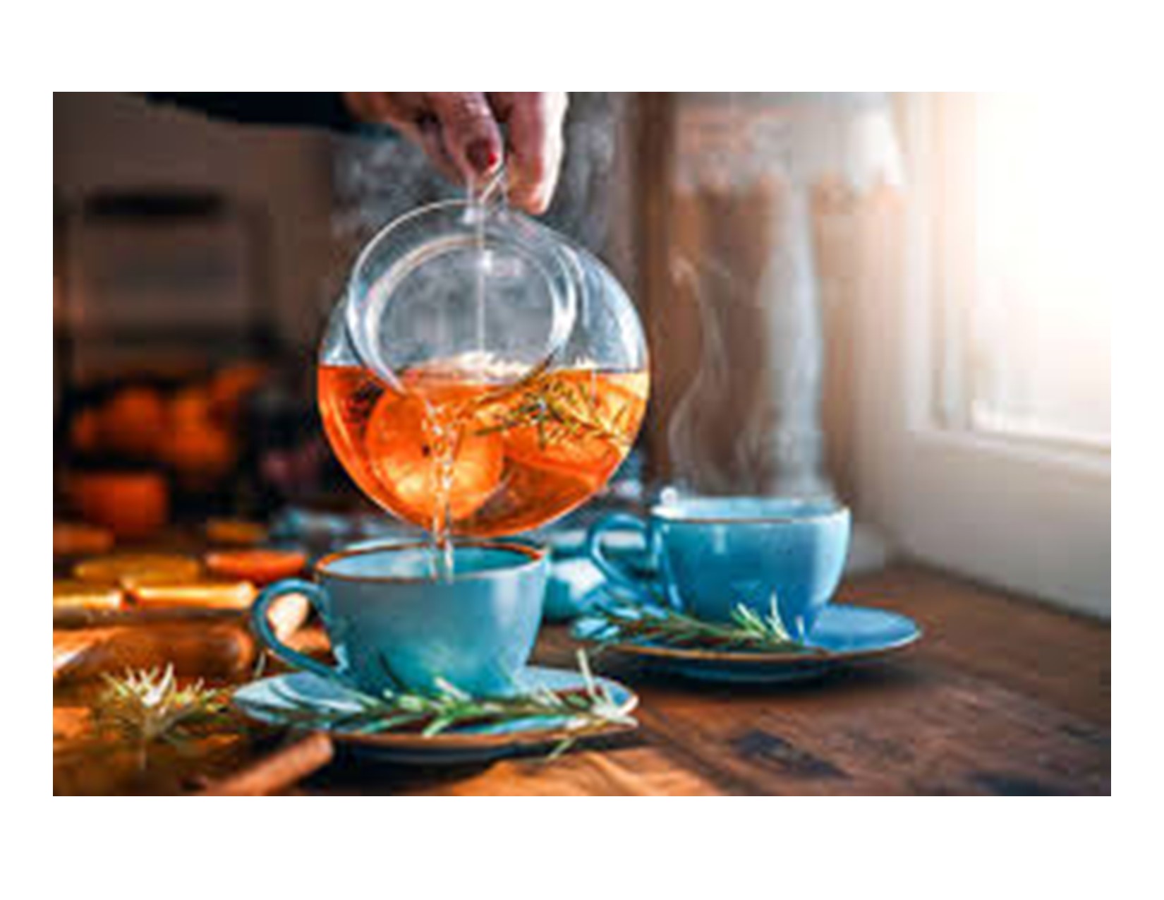 steaming tea being poured into a couple tea cups.