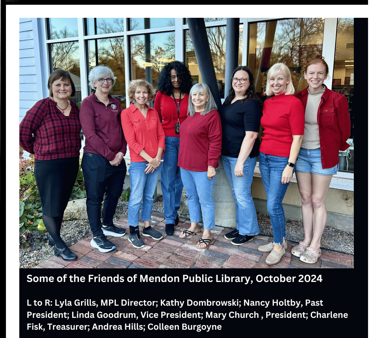 Photo of some of the Friends of Mendon Public Library standing outside the library where they placed a new commemorative brick for their Past-President, Nancy Holtby, 3rd from left in the picture.